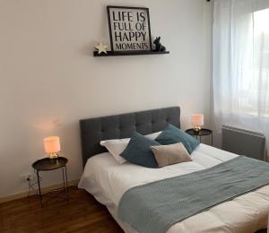 sypialnia z łóżkiem z napisem na ścianie w obiekcie Appartement cosy proche plage et centre ville w mieście Granville