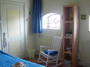 a bedroom with a bed and two chairs and a window at Bed and Garden Alde Coninckshof in Weurt