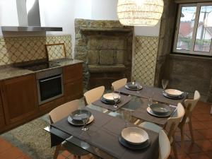 uma sala de jantar com uma mesa e cadeiras numa cozinha em Casa do Giraldo - Alojamento Local em Arcos de Valdevez