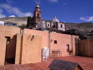 a patio with a white chair on top of a building at Hotel San Pancho in Real de Catorce