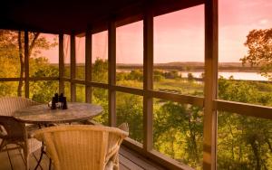 a table on a porch with a view of a river at Goldmoor Inn & Resort in Galena