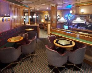 a bar with chairs and tables in a restaurant at Ramkota Hotel - Casper in Casper