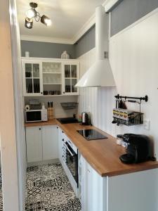 uma cozinha com armários brancos e um balcão de madeira em PÁLFFY em Bratislava