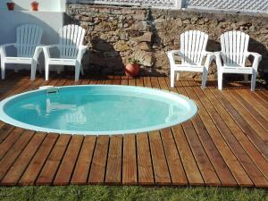 una piscina en una terraza con 2 sillas y una mesa en Casa Vitorino's, en Vale de Maceira