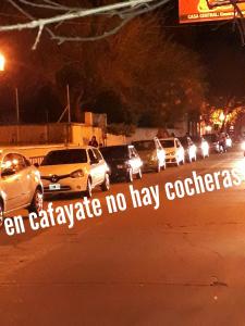 a group of cars parked on a street at night at Hostería El Zaguan in Cafayate