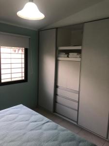 um quarto com uma cama e um armário de vidro em Santa Rita em San Rafael