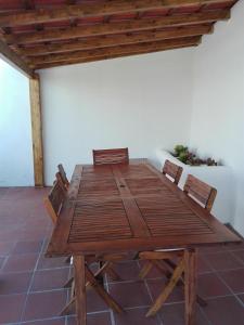 Casa Vitorino's في Vale de Maceira: طاولة وكراسي خشبية في الغرفة