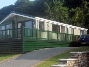 a green and white house with a car parked in front of it at Lodge 283 in Saint Enoder