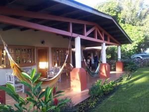 a porch with a hammock attached to a house at Spanish by the River - Boquete in Boquete