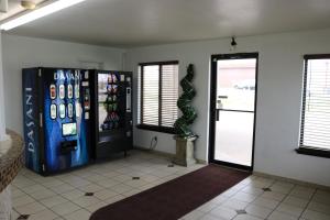 a room with a soda machine next to a door at Heritage Inn & Suites in El Dorado +8 photos