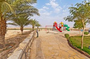 um parque infantil na praia com palmeiras em Al Malfa Resort em Unayzah