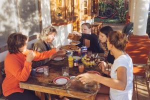 Un gruppo di persone seduti intorno a un tavolo che mangiano cibo di Spanish by the River - Boquete a Boquete