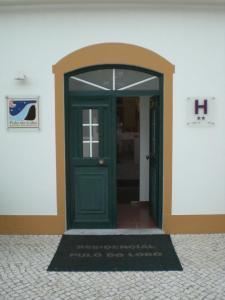 a green door with a welcome mat in front of it at Hotel Pulo do Lobo in Serpa