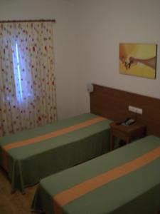 a small room with two beds and a window at Hotel Pulo do Lobo in Serpa