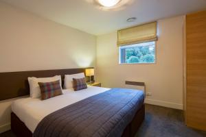 1 dormitorio con cama y ventana en Marina Apartments - Element Escapes, en Queenstown