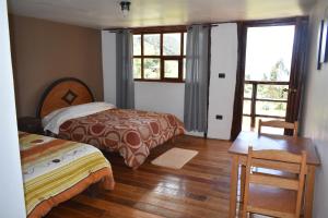 a bedroom with two beds and a wooden floor at CasaNostra Choquequirao in Cachora