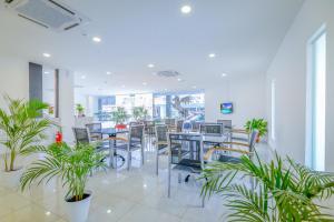 an empty restaurant with tables and chairs and plants at Fumah Hotel Kepong in Kuala Lumpur