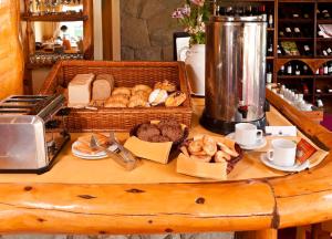 una mesa cubierta con una cesta de pan y bollería en Hostería Cumbres Blancas en Esquel