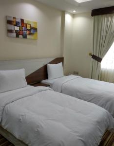 Säng eller sängar i ett rum på F & H Hotel