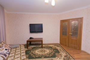 ein Wohnzimmer mit einem TV an der Wand in der Unterkunft Apartment on Sarayshyq in Astana
