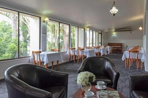 a dining room with tables and chairs and windows at Toowoomba Motel & Events Centre in Toowoomba