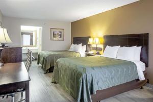 a hotel room with two beds and a table at Quality Inn & Suites Live Oak I-10 Exit 283 in Live Oak +27 photos