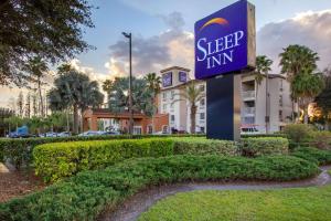 um sinal para uma estalagem de sono em frente a um edifício em Sleep Inn near Busch Gardens - USF em Tampa