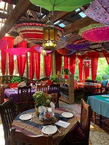 a dining room with tables and chairs and umbrellas at Rabbit Hole Hotel in Krugersdorp