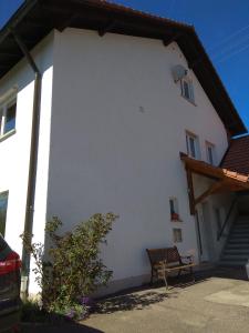 a white building with a bench in front of it at Amy's Apartment, relax and enjoy in Bonndorf im Schwarzwald