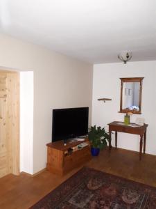 ein Wohnzimmer mit einem Flachbild-TV und einem Tisch in der Unterkunft Villa Sängerstein in Eisenach