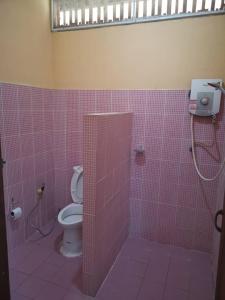 a pink tiled bathroom with a toilet and a shower at Promma Farm Resort in Ban Tat Ton (1)