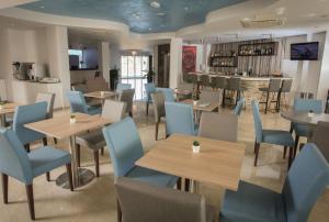a restaurant with tables and chairs and a bar at Bellini Hotel in Ayia Napa