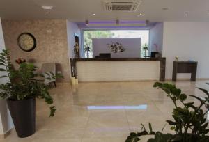 a lobby with a reception desk and potted plants at Bellini Hotel in Ayia Napa