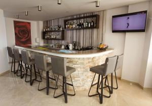 a bar with chairs and a television in a room at Bellini Hotel in Ayia Napa