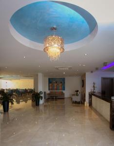 a large lobby with a chandelier and a large room at Bellini Hotel in Ayia Napa