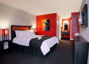 a hotel room with a large bed with red walls at Hotel Ruby in Spokane