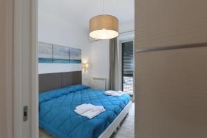 a bedroom with a blue bed in a room at Cartolina Apartment in Taormina