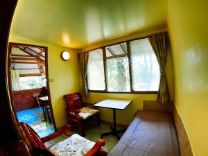 ein kleines Zimmer mit einem Tisch, Stühlen und Fenstern in der Unterkunft Rock Inn Bailan in Ko Chang