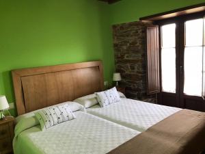 San Tirso de AbresにあるApartamentos Carolaの緑豊かなベッドルーム(ベッド2台、窓付)
