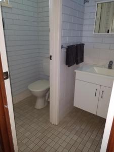 a white bathroom with a toilet and a sink at Villa Skywalk in Kalbarri