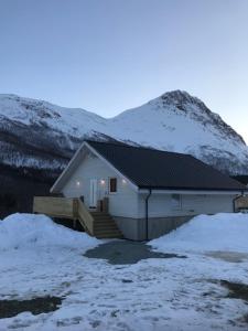a house in the snow with a mountain at Kjelkebakken gård 2. in Lyngseidet