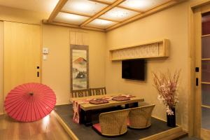 a dining room with a table and a pink umbrella at Guesthouse Raku in Kyoto