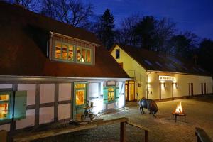 a cow standing outside of a house at night at Apartment 5 - Gourmetzimmer in Bestensee