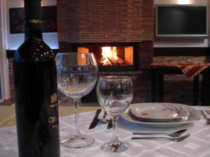 a table with two wine glasses and a bottle of wine at Aleksandar Villa & Spa in Ohrid