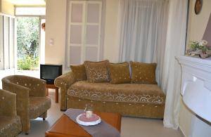 a living room with a couch and a tv at Stam House in Leonidio