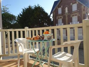 een tafel met een bord brood en fruit op een balkon bij Plazza front de Mer in Villers-sur-Mer