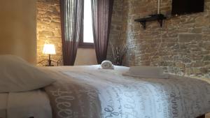 een slaapkamer met een groot bed en een stenen muur bij Bed & Breakfast Antico in Motovun