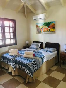 a bedroom with two beds and a painting on the wall at Blue Bay golf en beach, Dushi na kas, villa 36 in Blue Bay