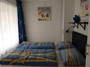 a bedroom with a bed with a blue blanket and a window at BRANDING Bed by the Sea in Westkapelle