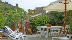a patio with a table and chairs and an umbrella at La Nave in Vernazza
